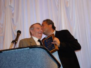 Kevin Lipton (right) kisses John N. Rowe III