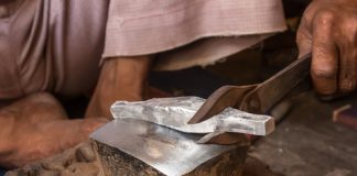 Gold, Silver Advance on Week; US Mint Bullion Coin Sales Mixed silversmith at workshop creating silver jewlery